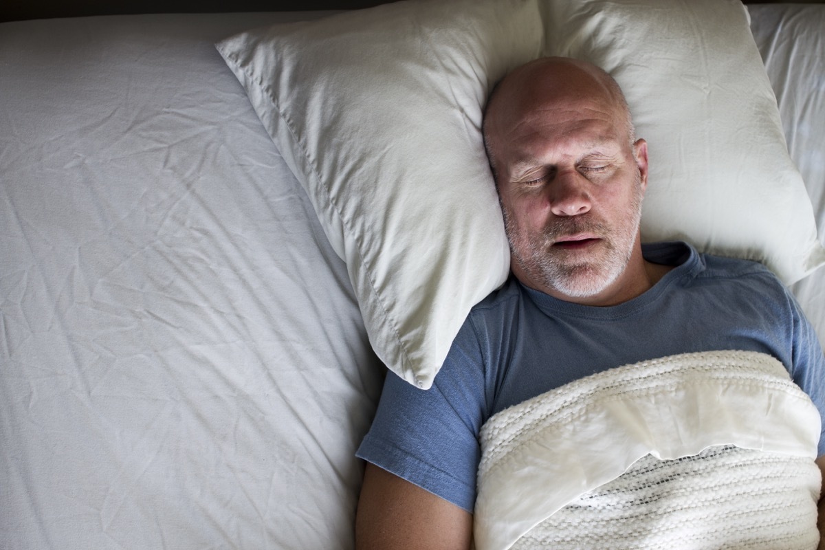 Overhead photo of a man sleeping in a bed.