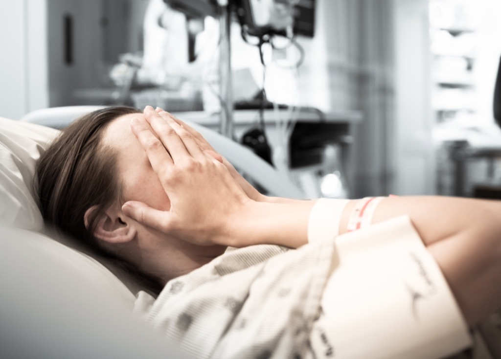 Woman crying in a hospital bed.