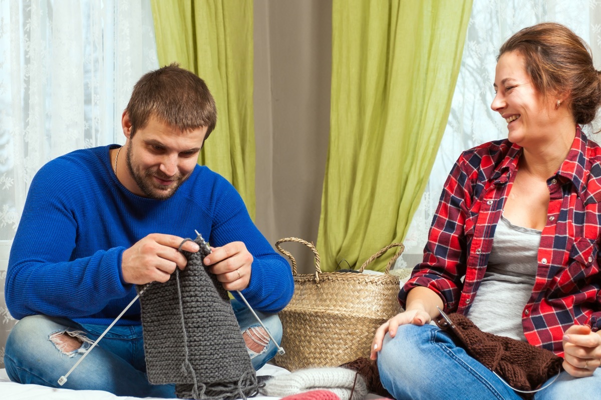 Woman teaching man to knit