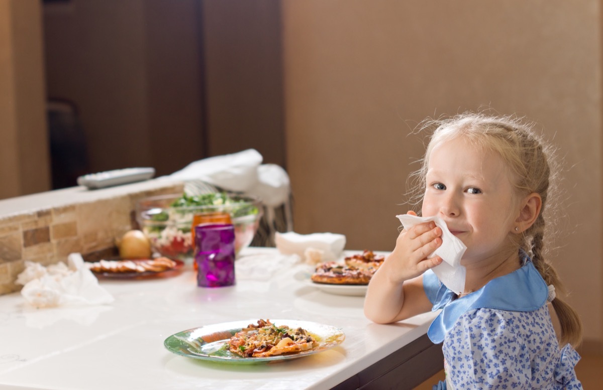 Young blonde girl sitting eating whipping her both being polite