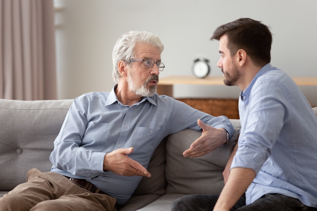 older man on couch looking annoyed