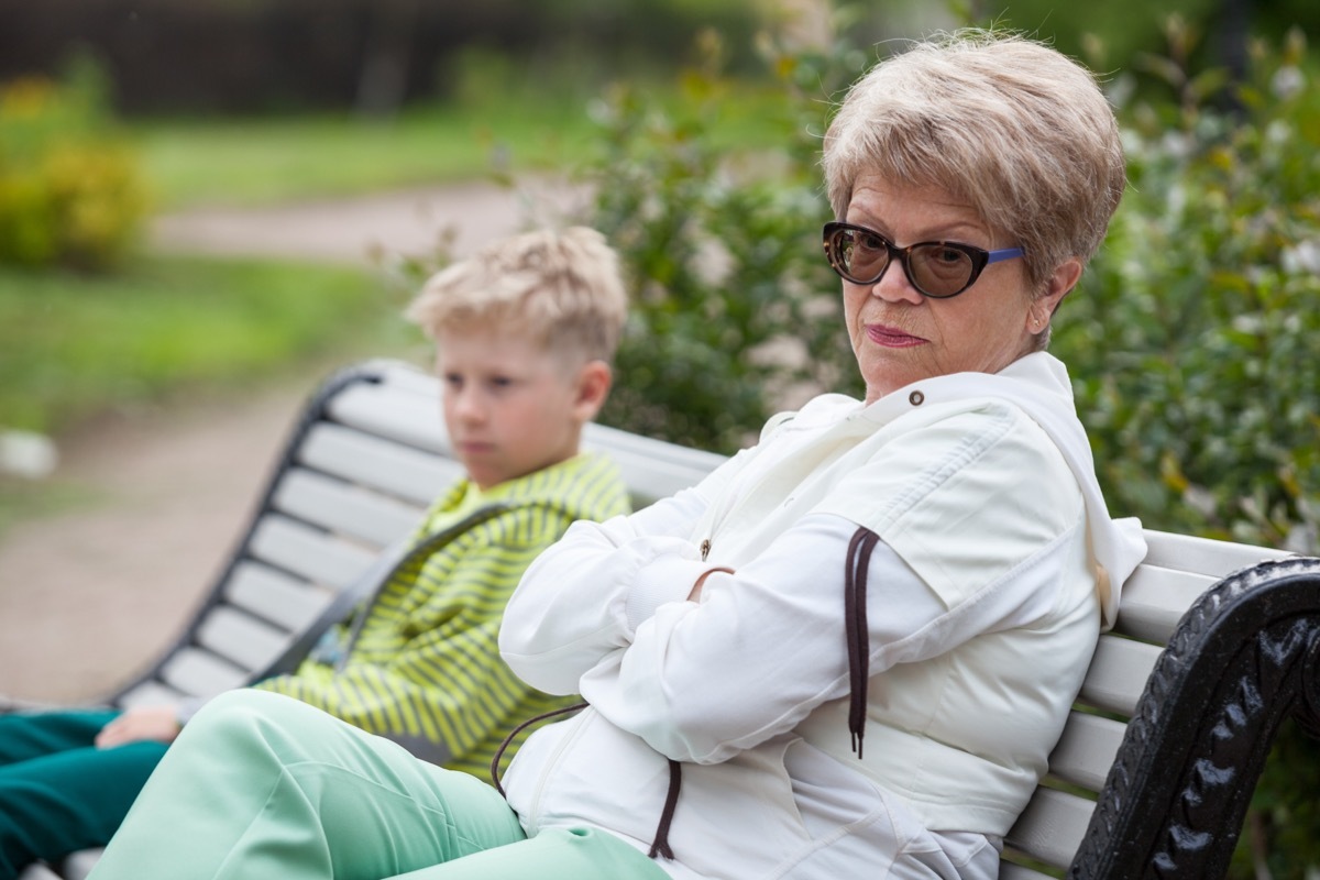 angry white grandmother and grandson on bench