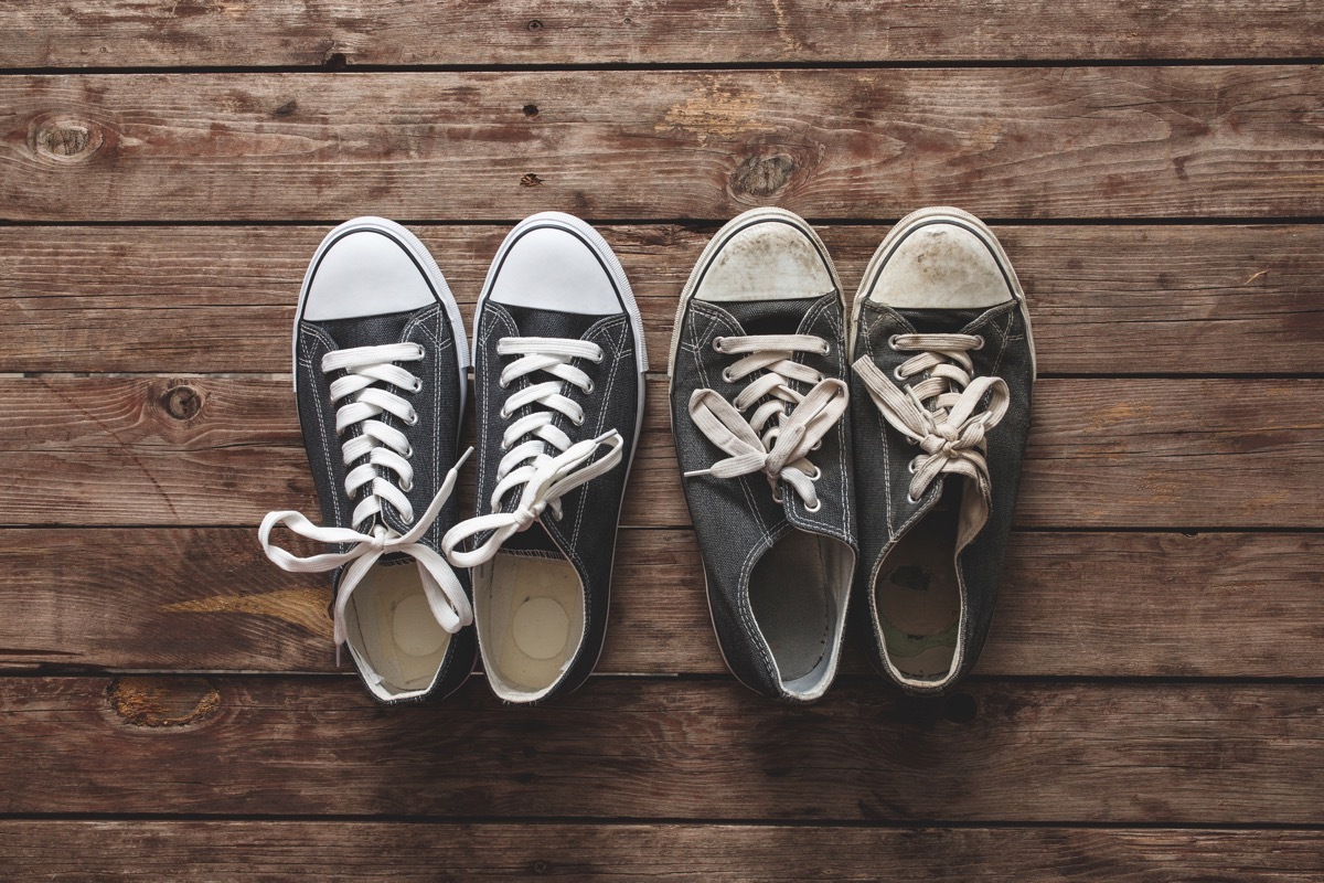 new and old sneakers on wooden background.