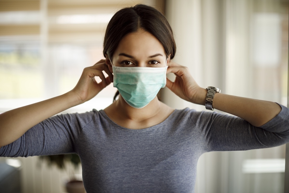 Portrait of young woman putting on a protective mask for coronavirus isolation