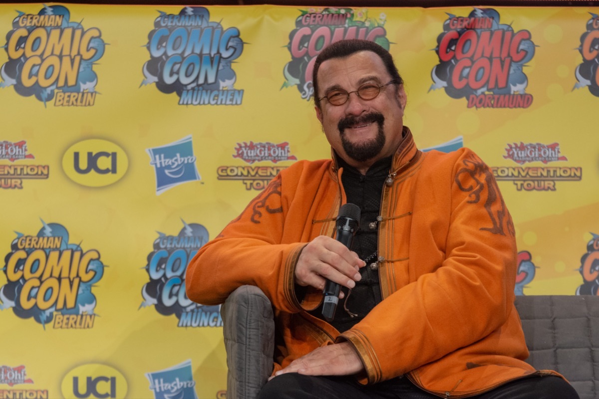 steven seagal in orange jacket during interview