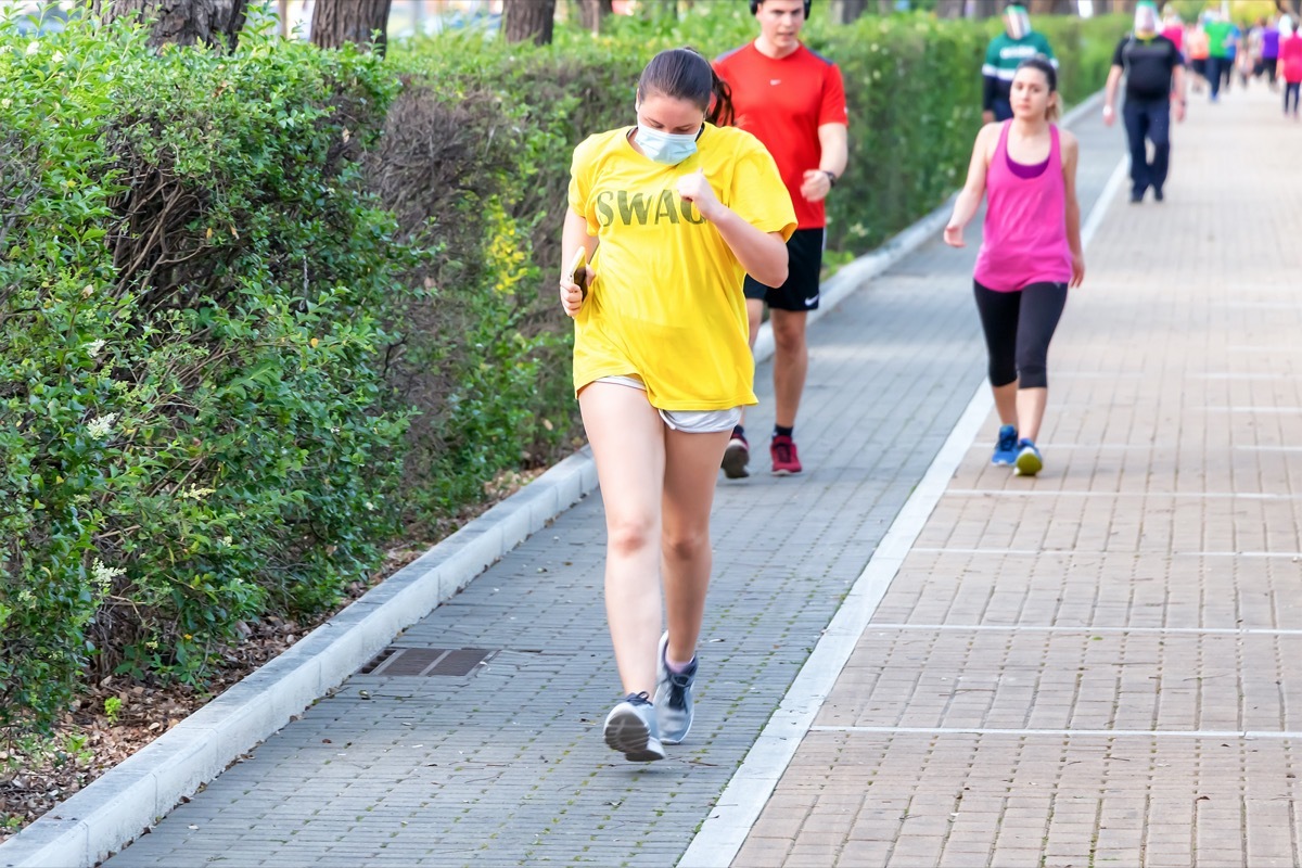 Woman running and do exercise wearing a protective face mask