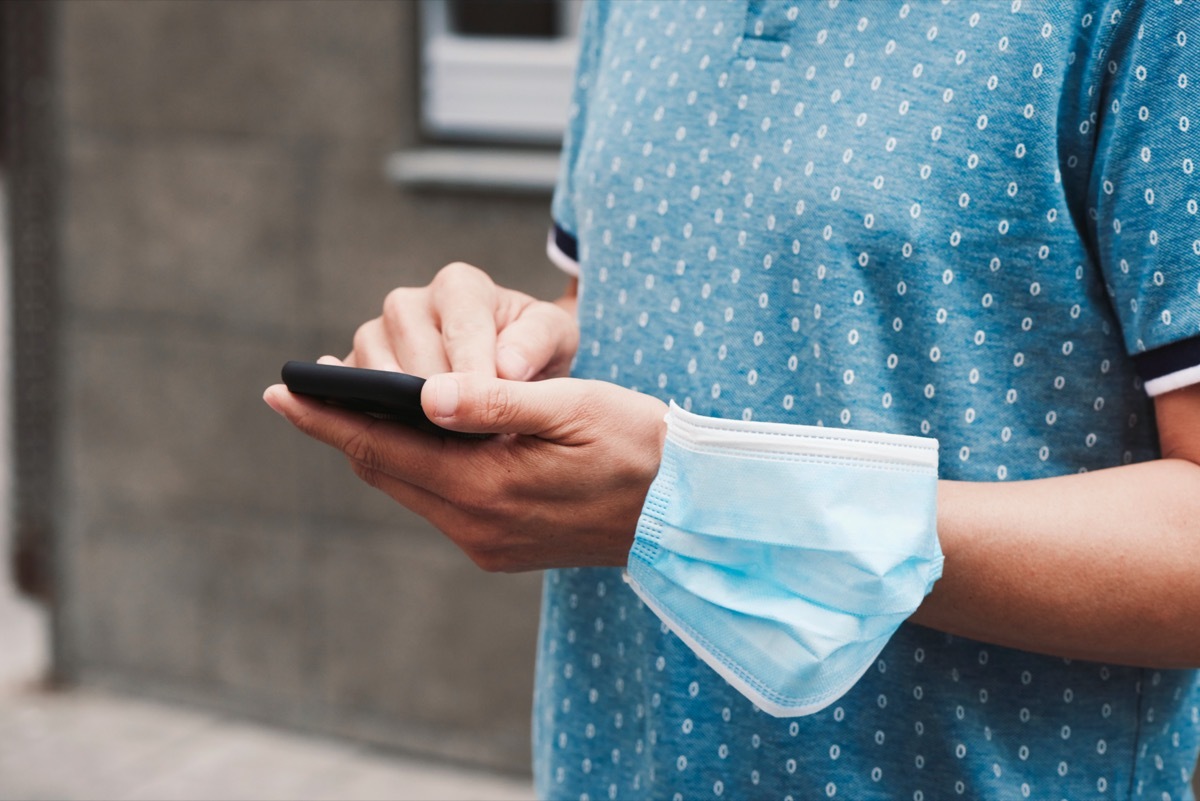 man wearing coronavirus face mask on wrist