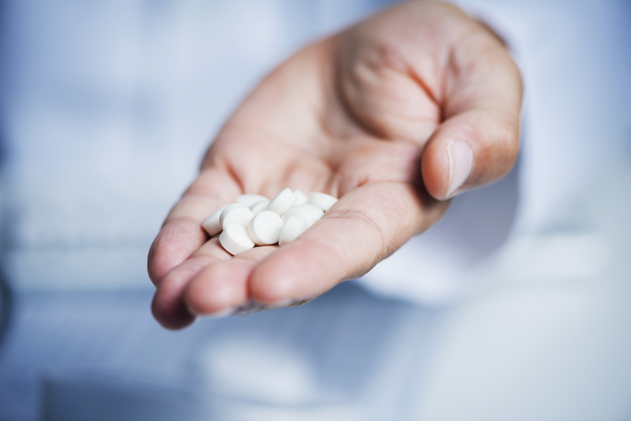 Pills in the palm of a person's hand.