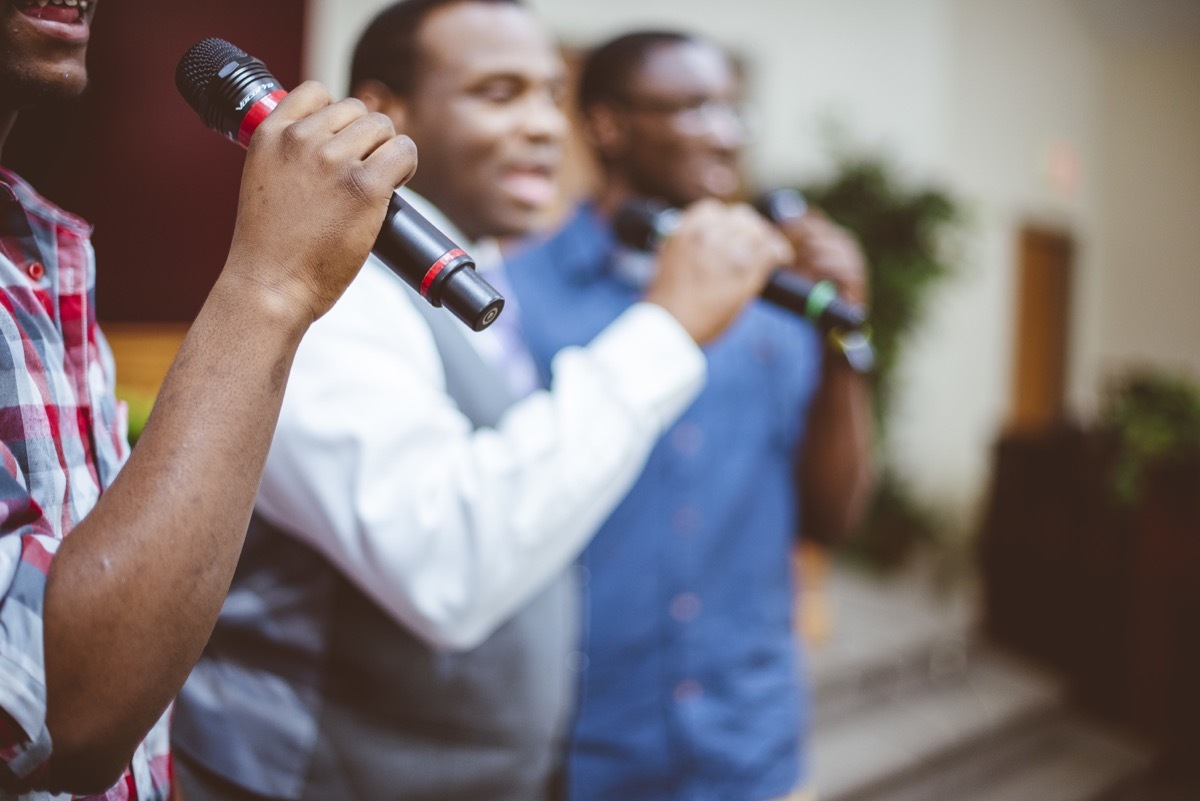 men singing in church with microphones