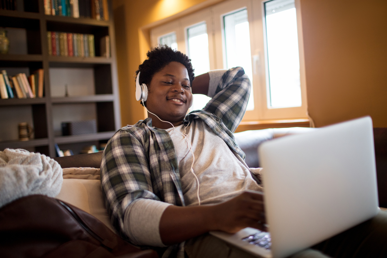 young black man listening to music and smiling