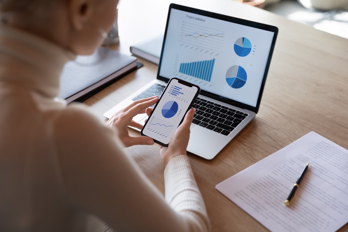 Woman using budgeting app on phone and computer