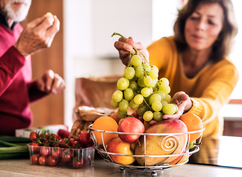 Woman with fruit in kitchen