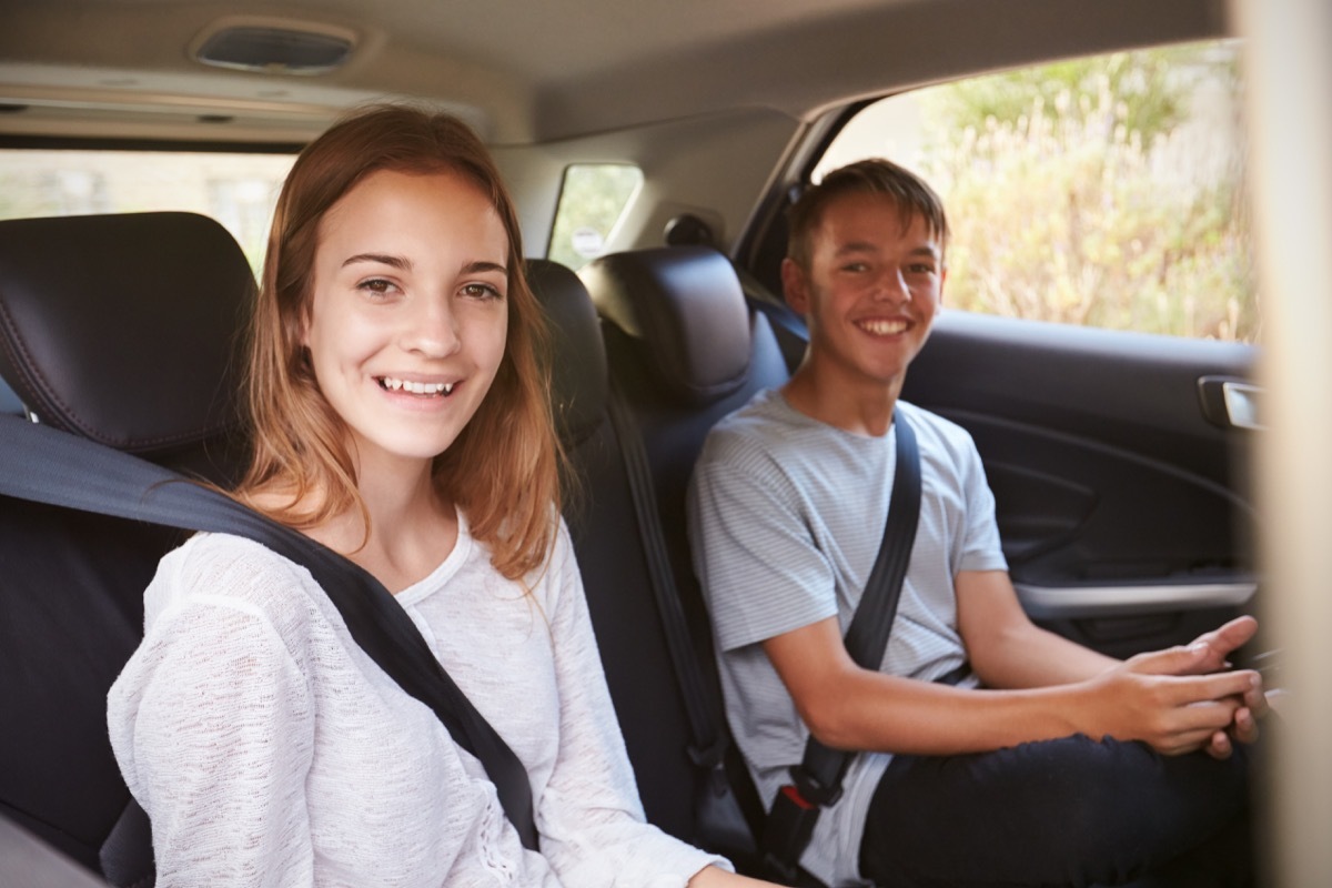 two white teenagers in the backseat of a car