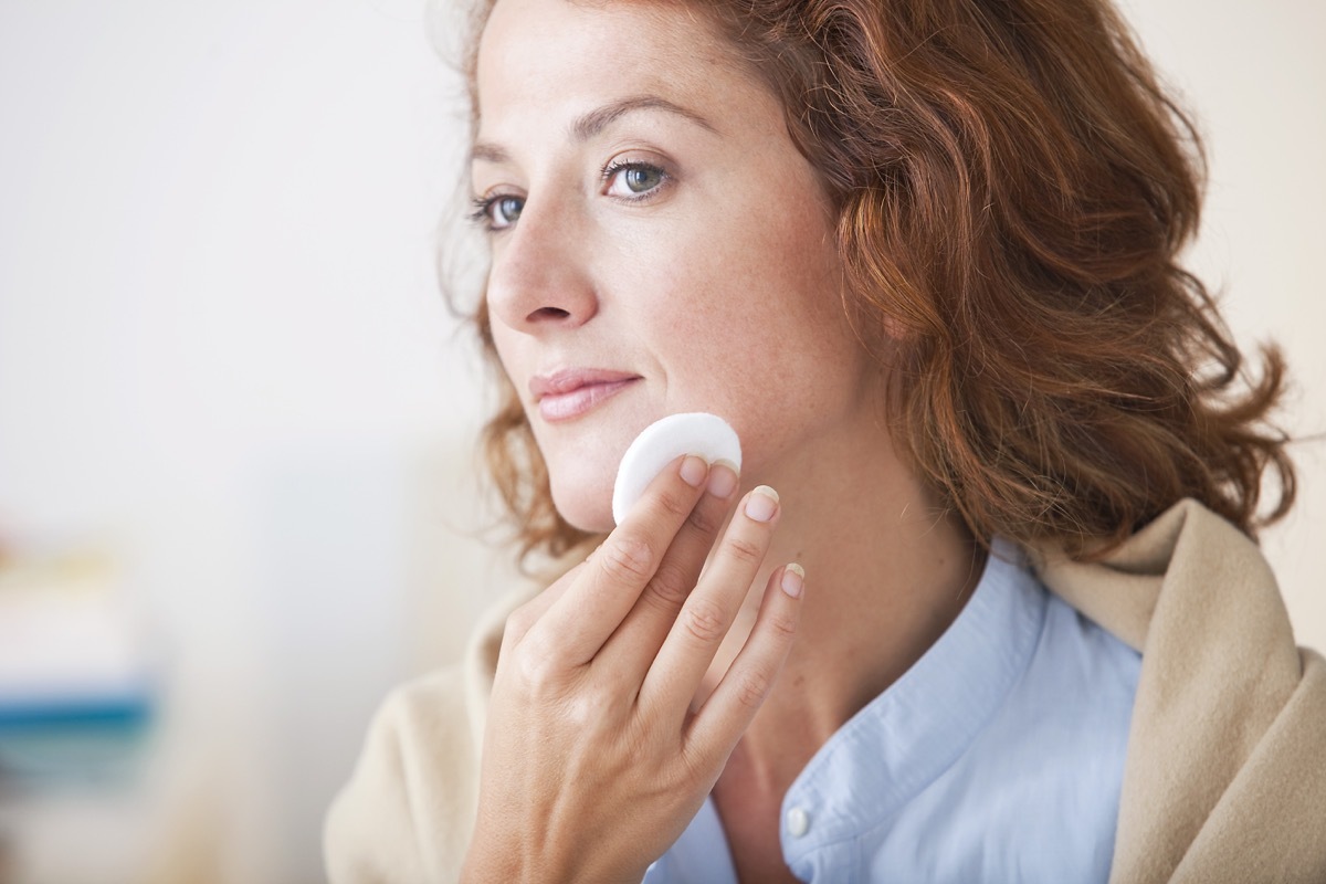 Woman using makeup remover to take off her makeup and clean her face