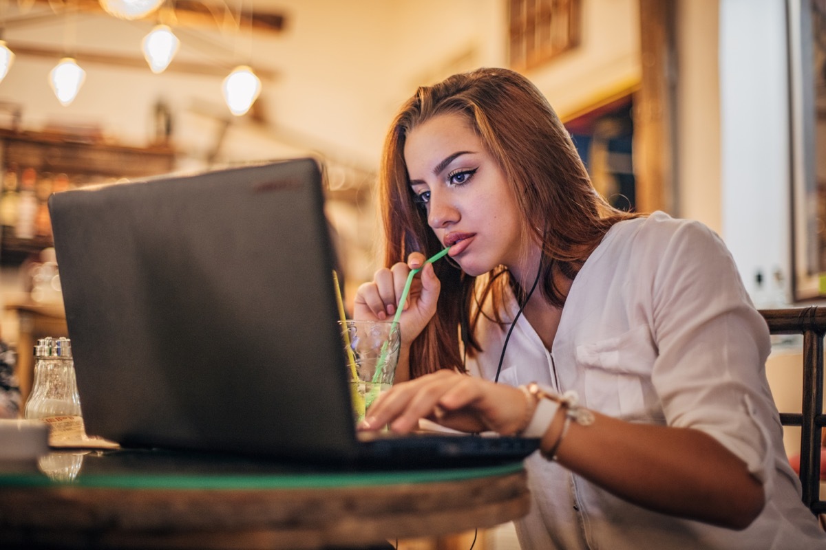 Young woman is using laptop and listening to music.