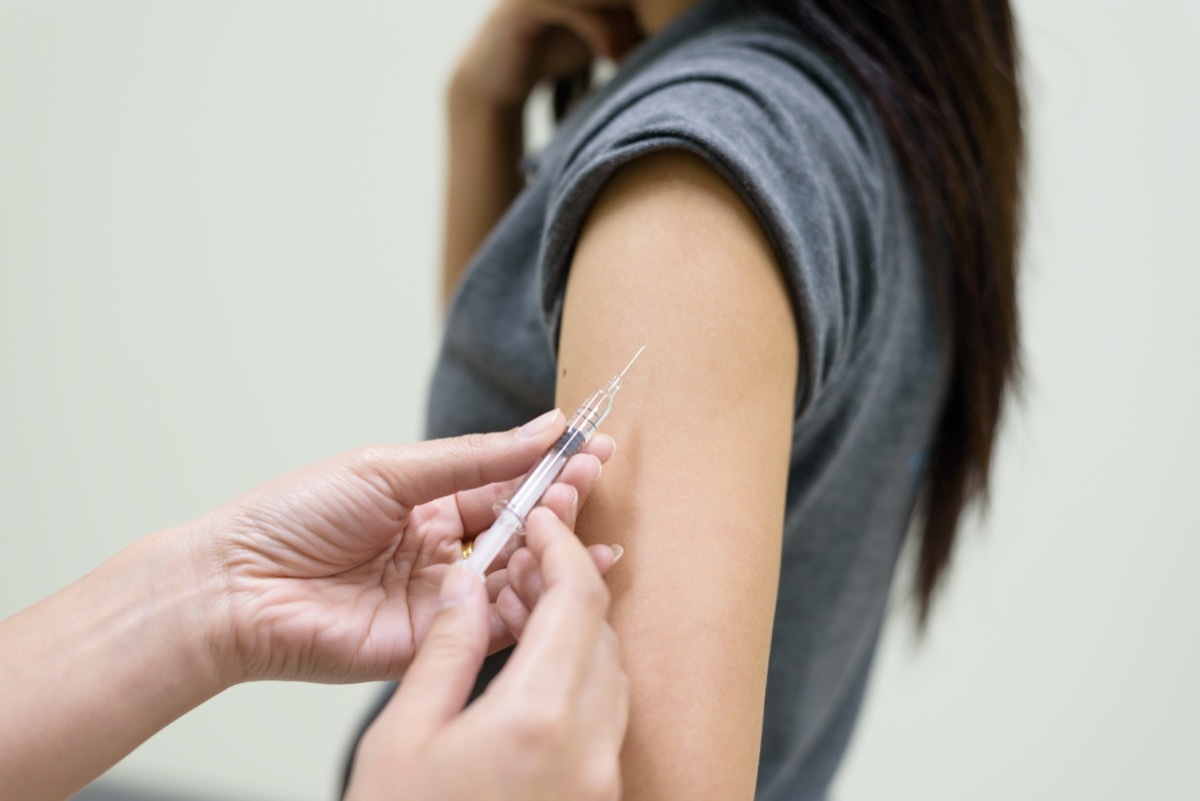 Close up doctor's hand injecting for vaccination in the shoulder woman patient