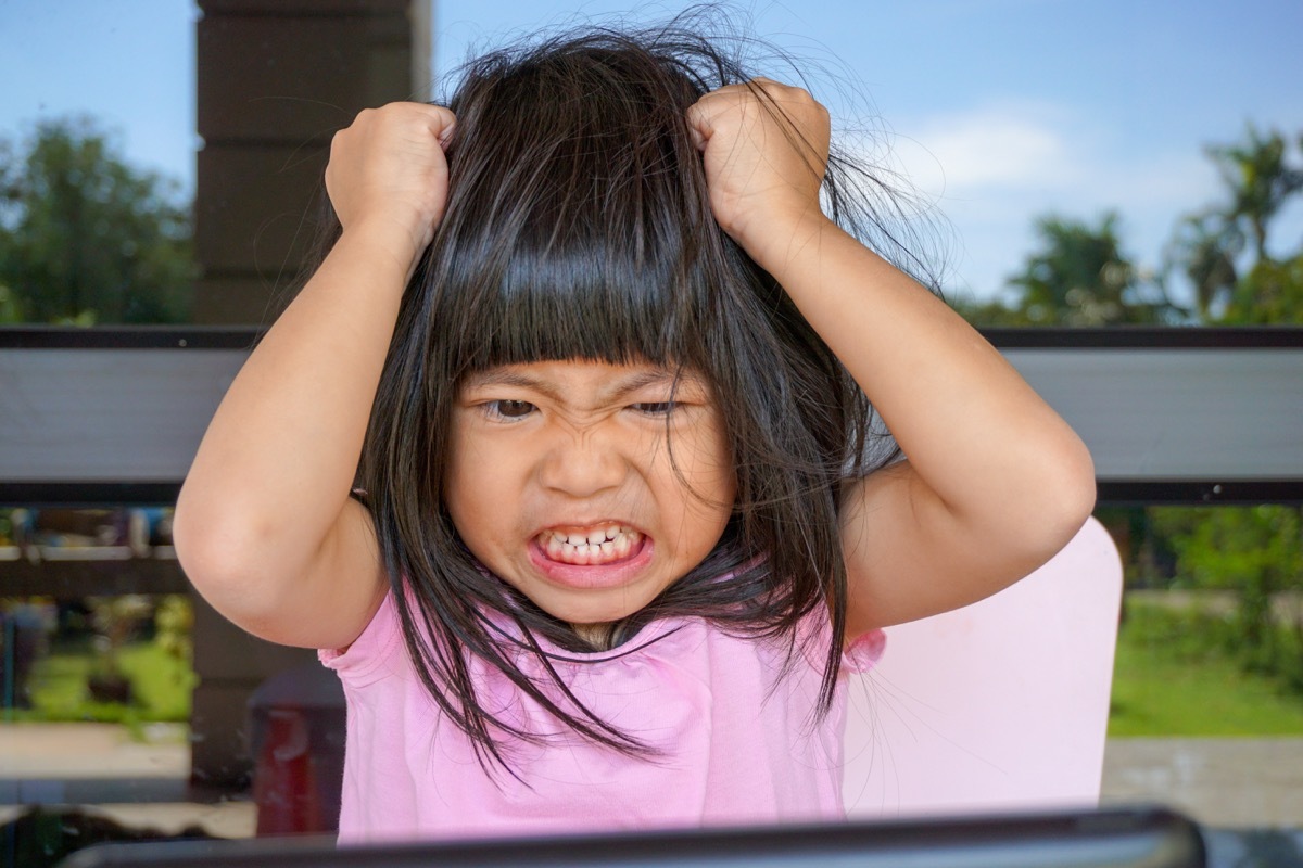 young asian child yelling and throwing fit