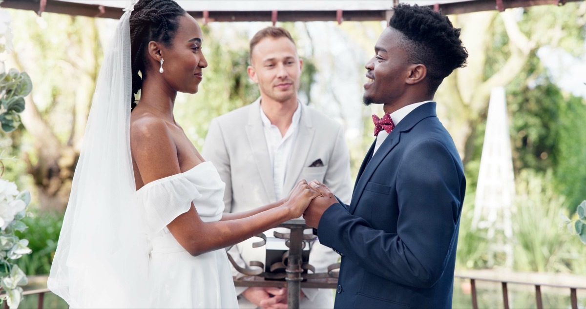 Bride and groom standing in front of officiant