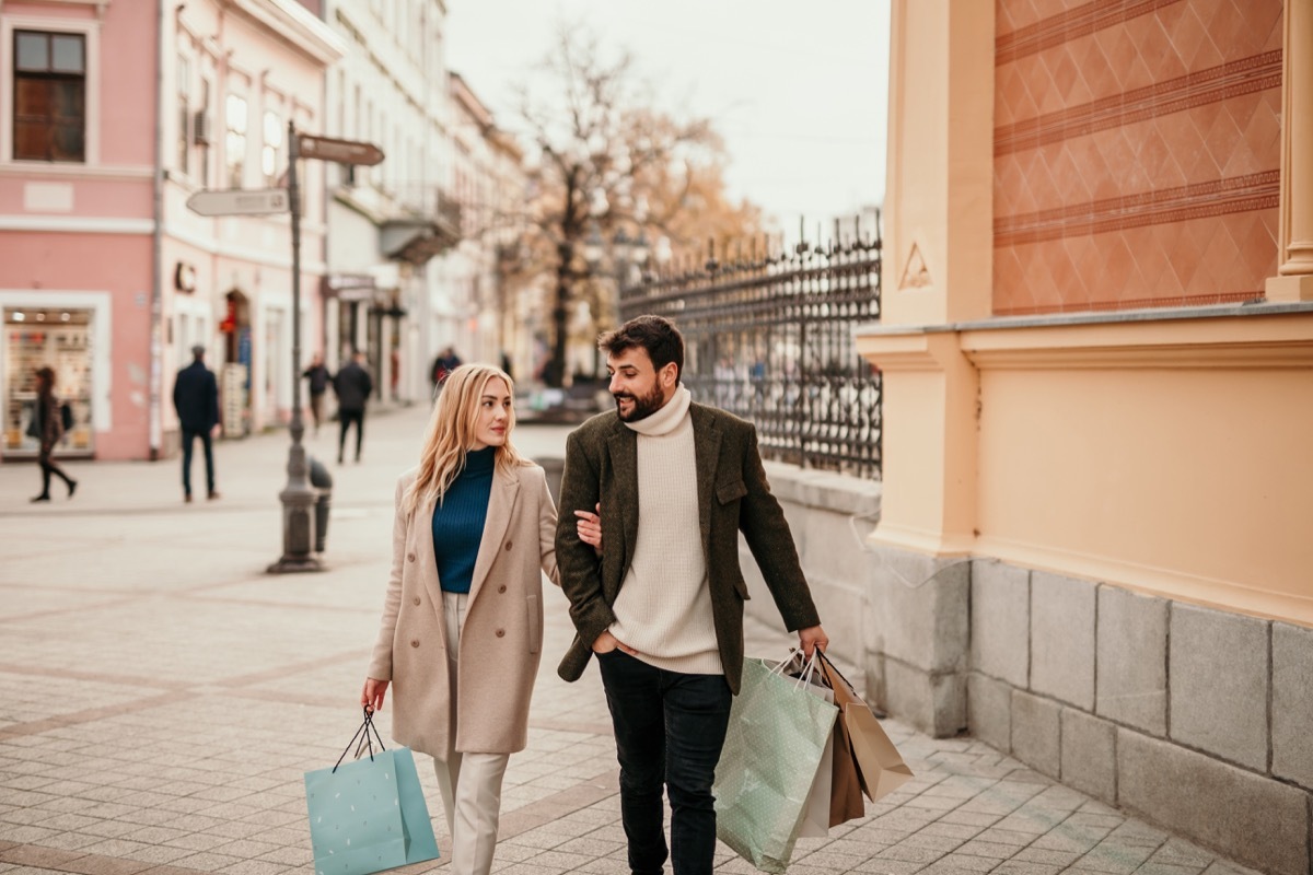 Happy tourist couple in love having fun, shopping, traveling, and smiling together on vacation. People's happiness concept.