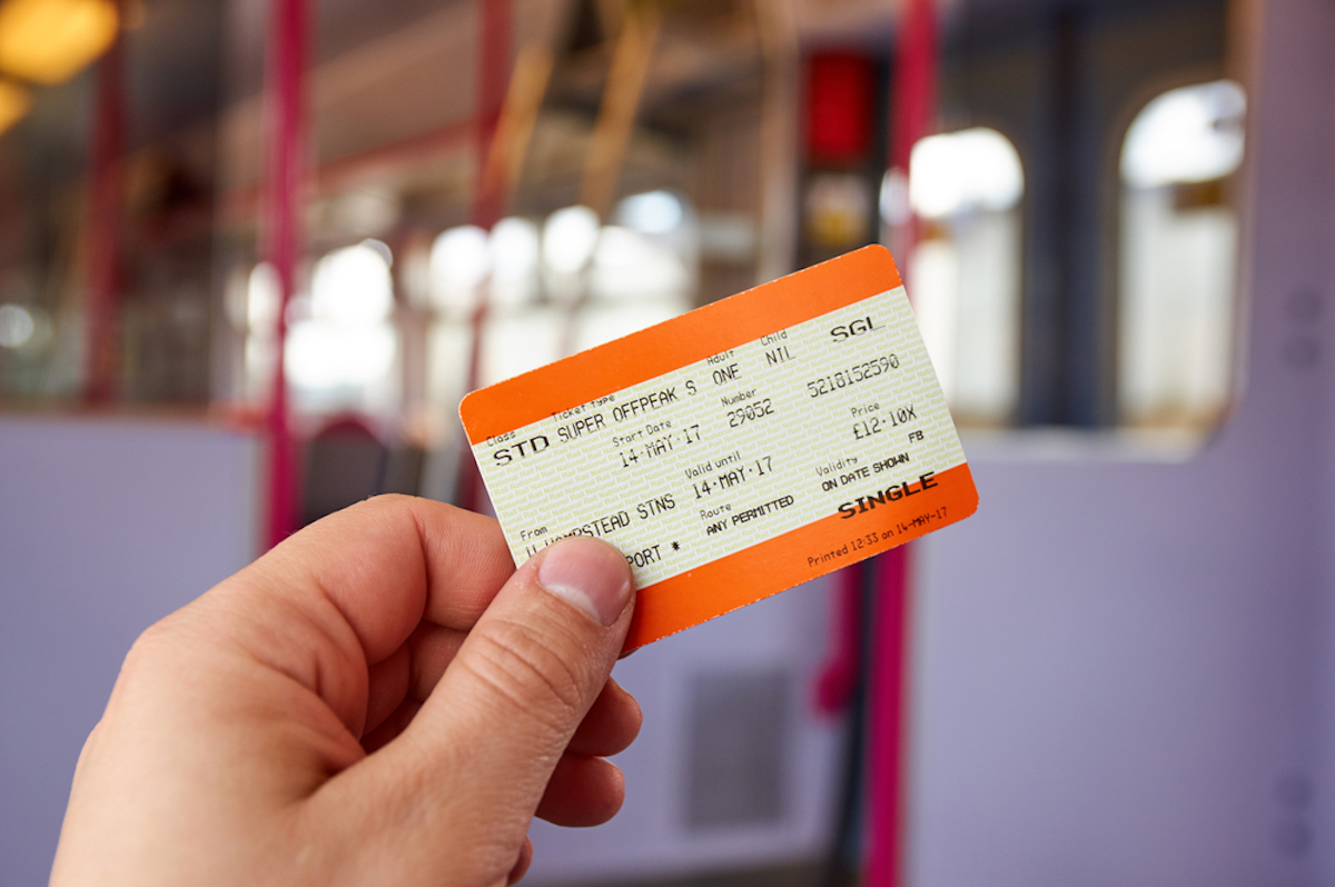 closeup of hand holding paper train ticket