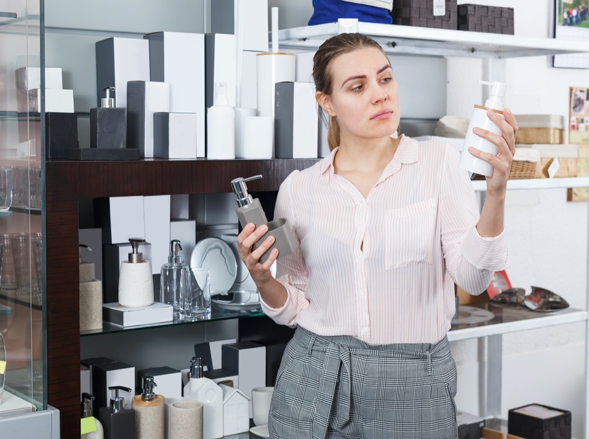 female choosing bottle for liquid soap in supermarket