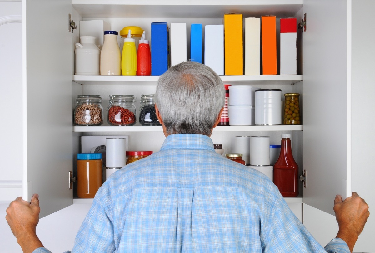 man looking in pantry