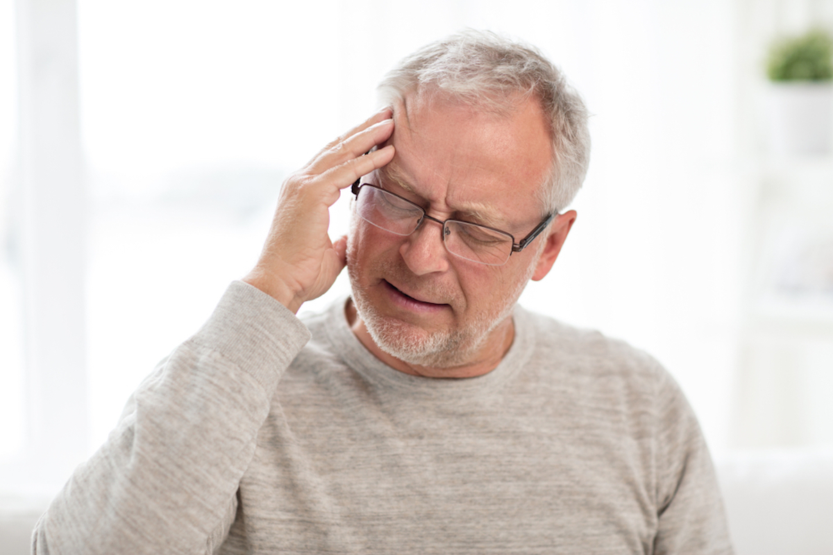 Senior man suffering from headache at home