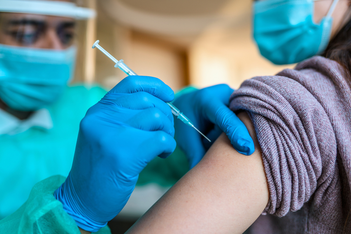 Doctor Vaccinating Female Mid Adult Patient in Doctor's Office