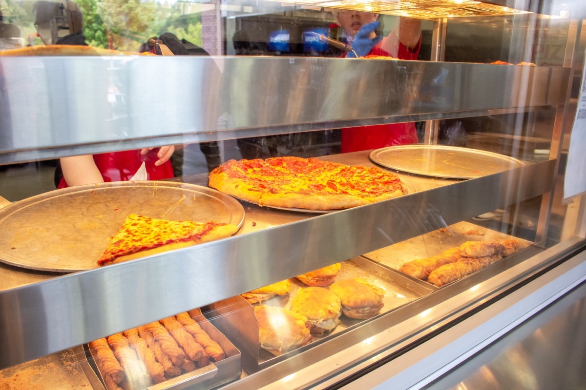 Looking into the window of the Costco cafeteria showing empty pans as many customers buy out food