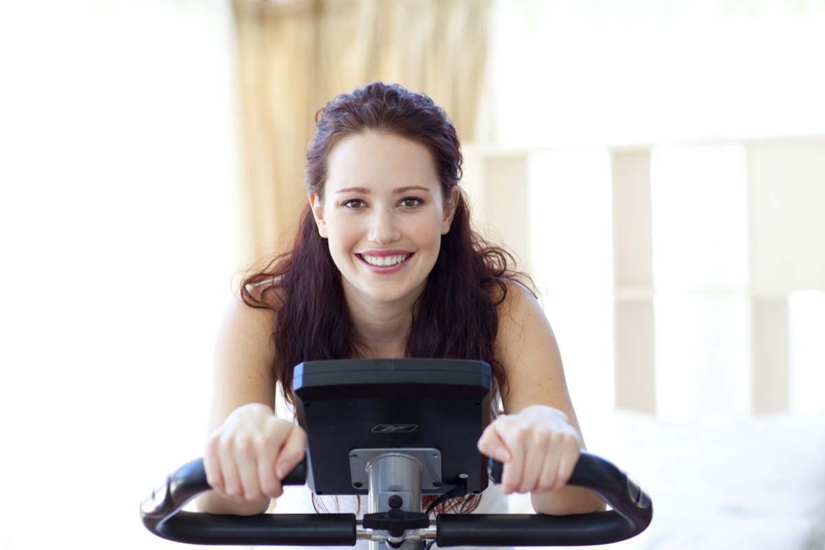 Smiling woman doing spinning in her bedroom at home