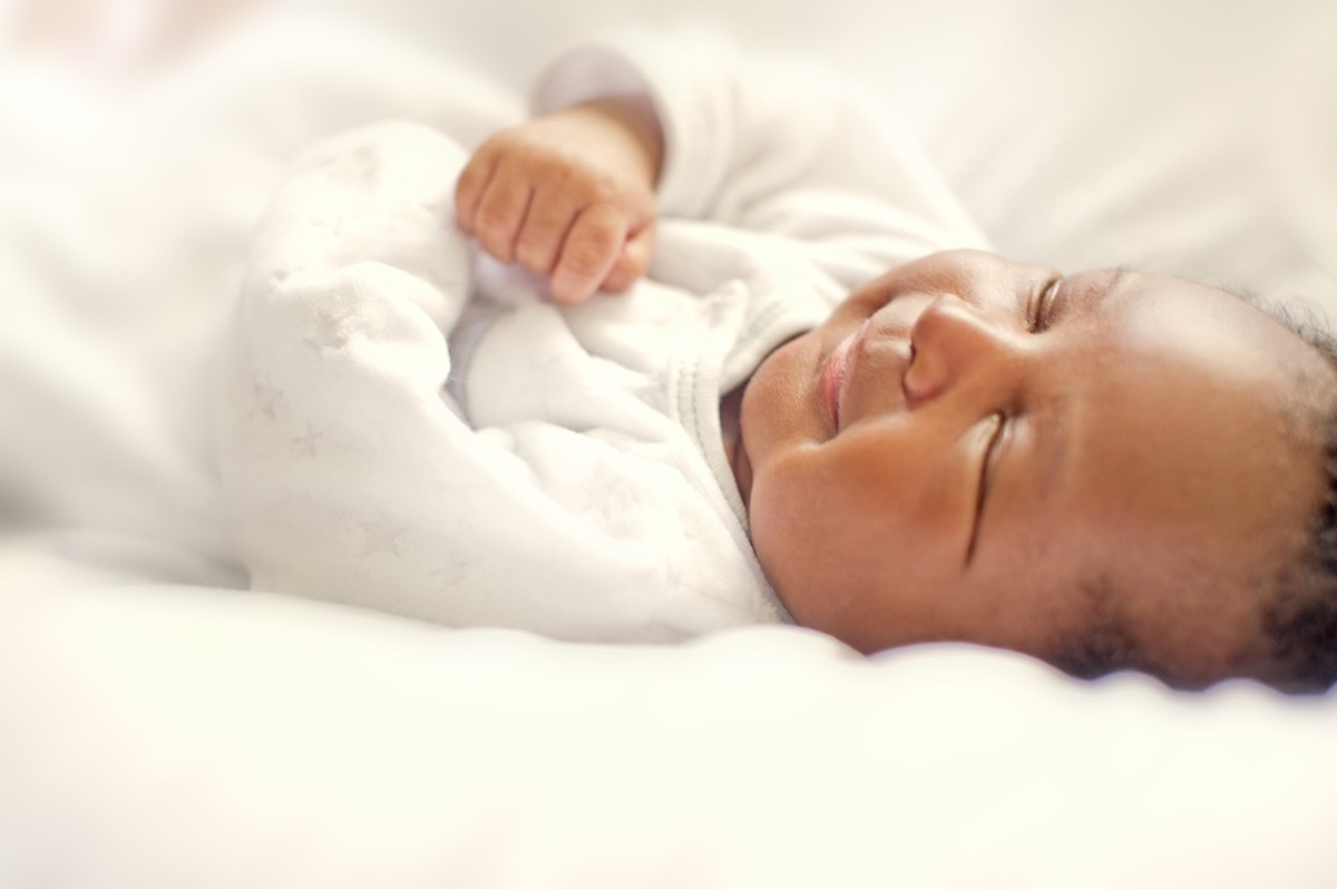 smiling black baby sleeping