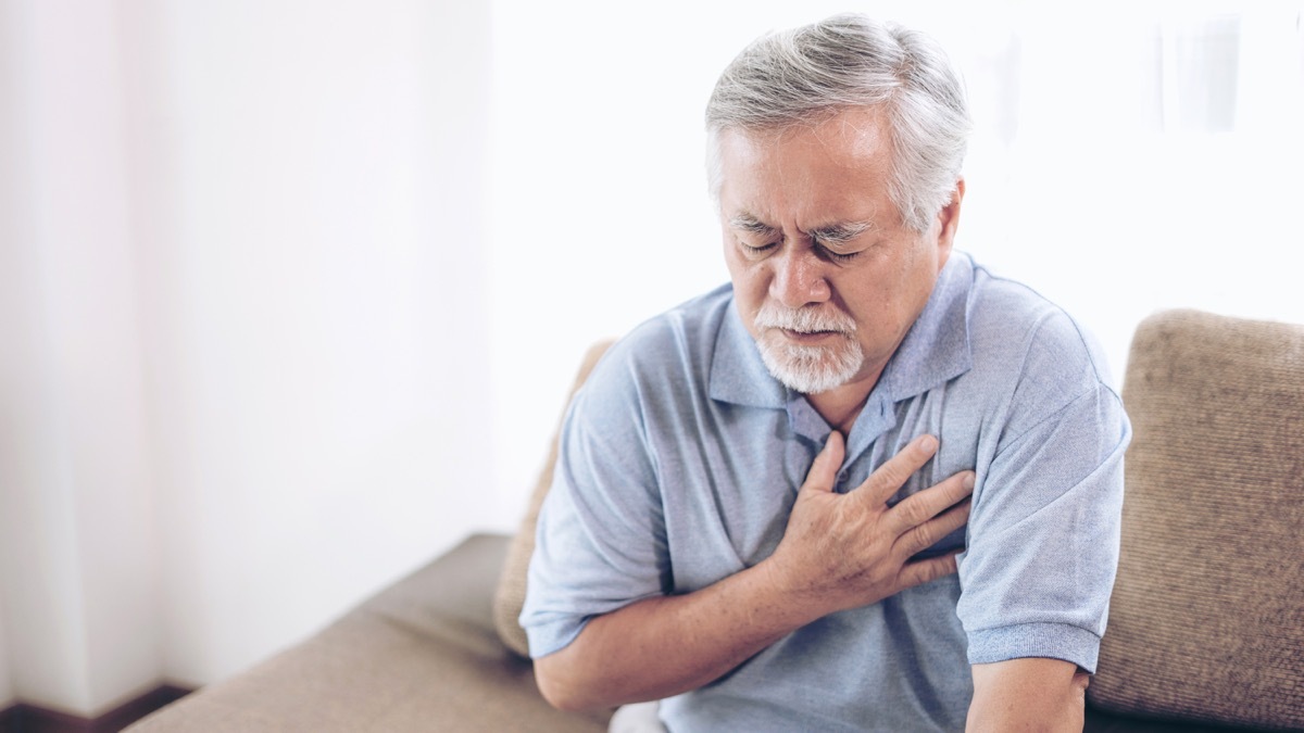 heartburn or chest pain for a man clutching his chest, health questions after 50