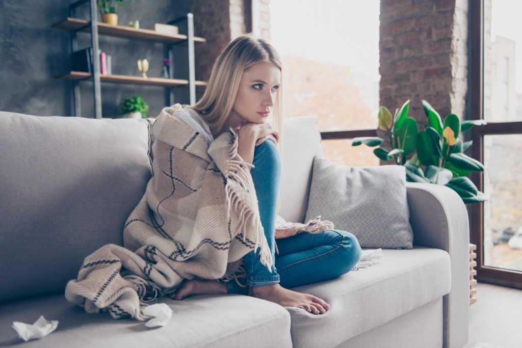 woman wrapped in blanket on a couch