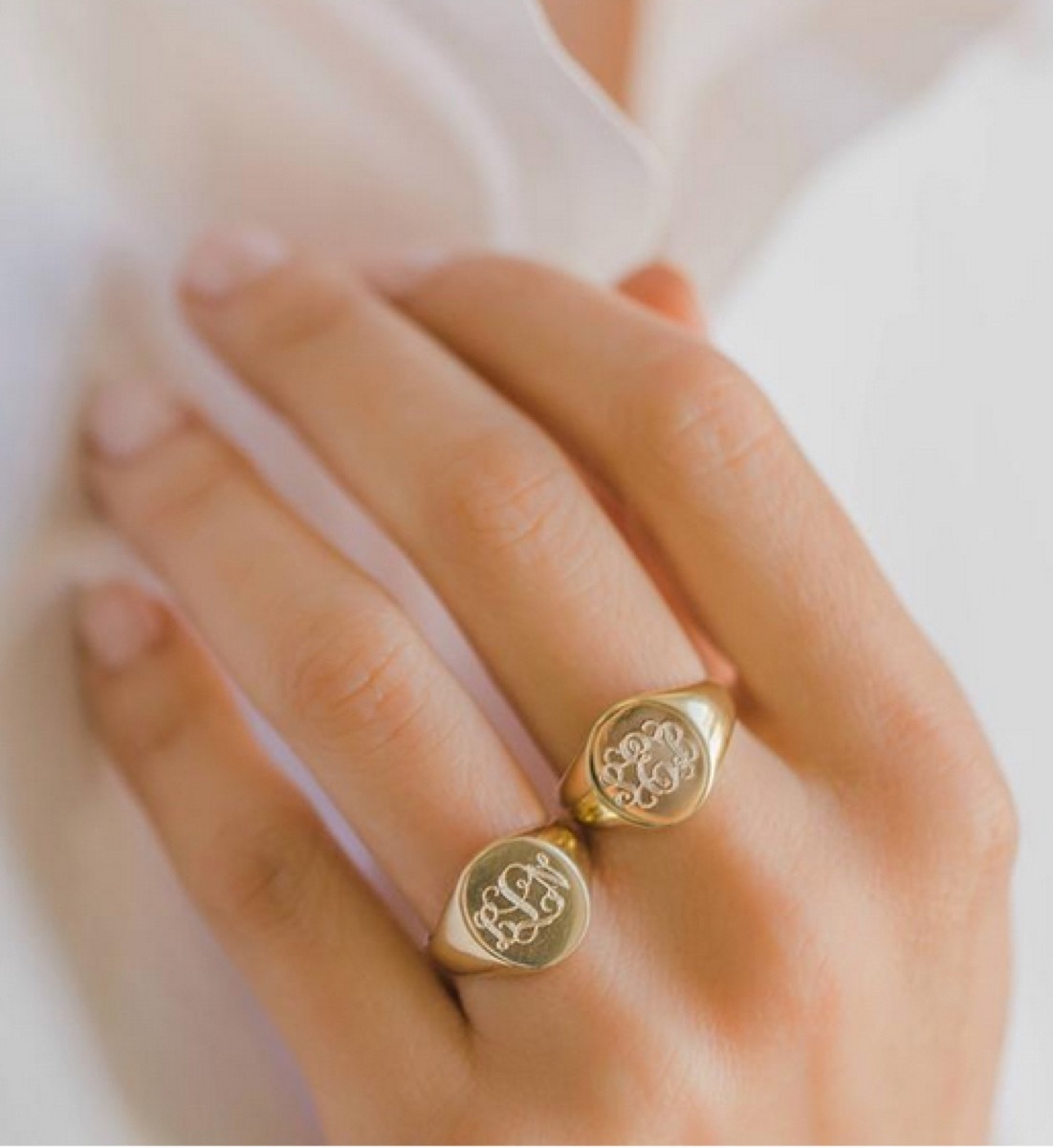 white hand wearing gold cignet ring