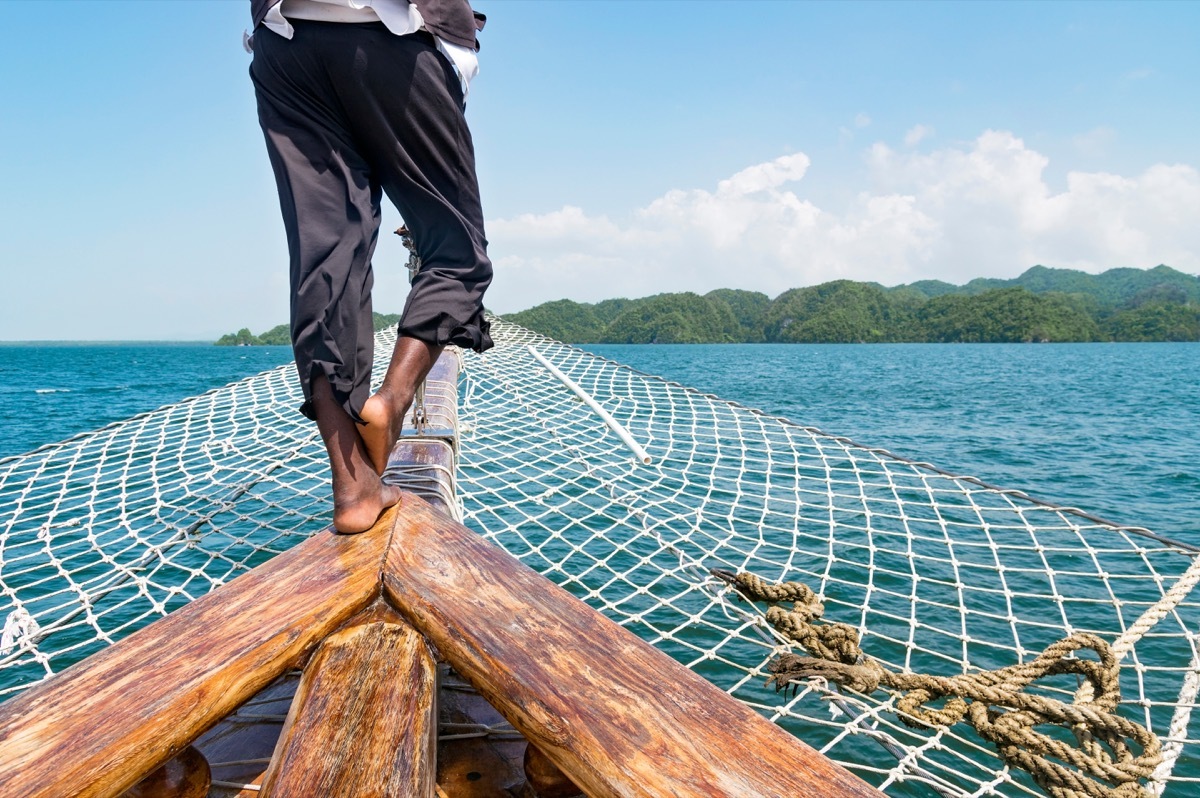 man dressed as a irate looks out over ship ocean