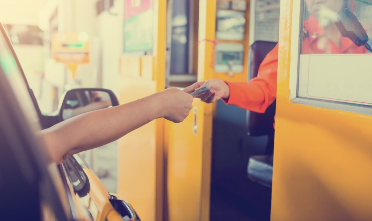 man paying toll fee with cash