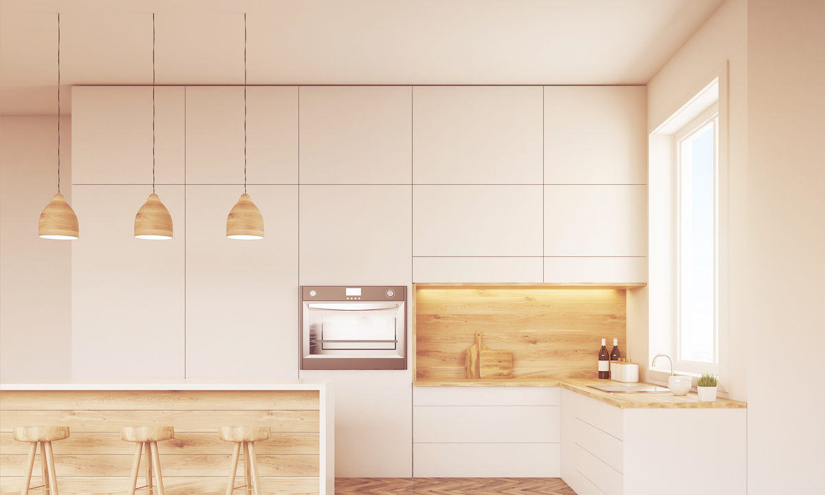 Front view of kitchen with oven, sink, countertops and window.