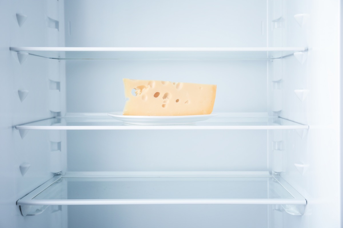 a block of cheese in an empty refrigerator