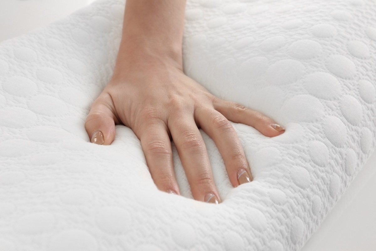 white hand on memory foam pillow