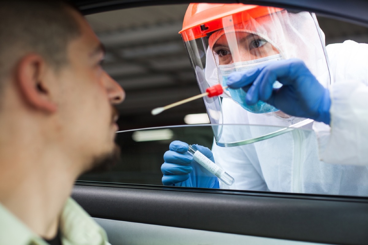 coronavirus test being administered to white man in car