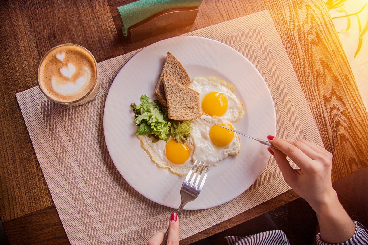 Person eating eggs and toast for breakfast