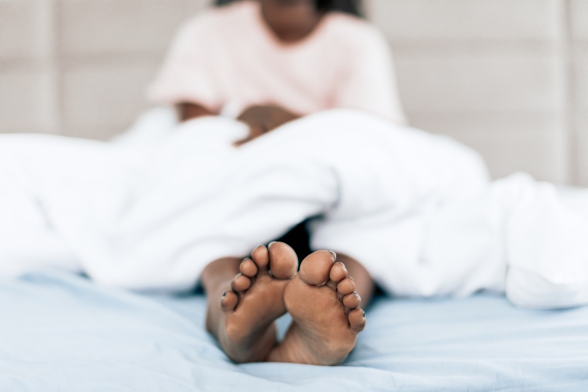 girl laying in bed with her legs out