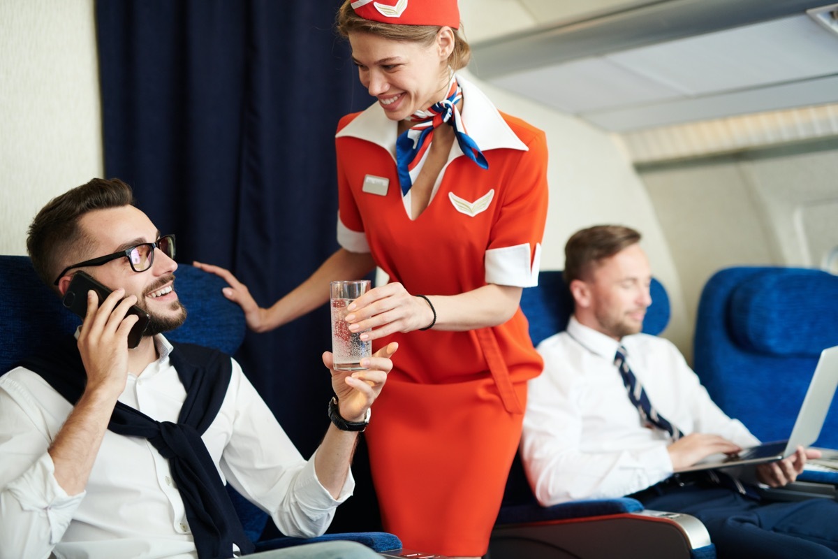 flight attendant helping a first class flyer