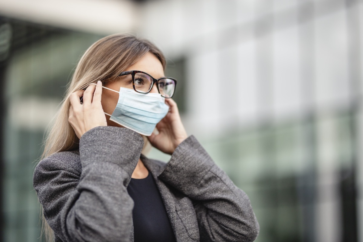 Woman put on medical protective mask for protection against coronavirus.