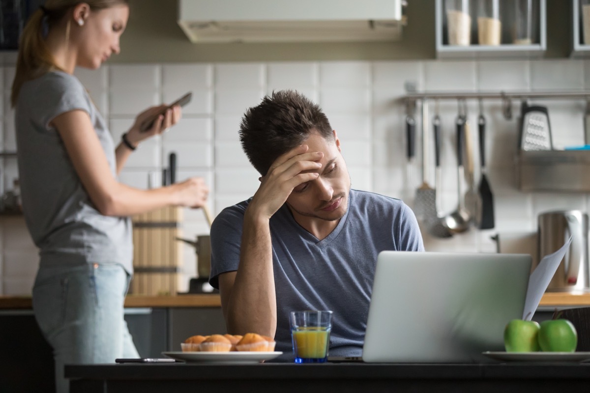 Couple that is growing apart doing different things in the kitchen