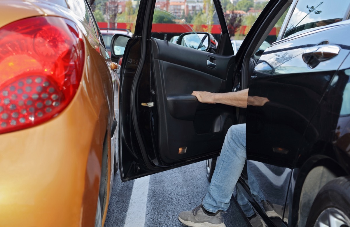 Person opening car door into another car