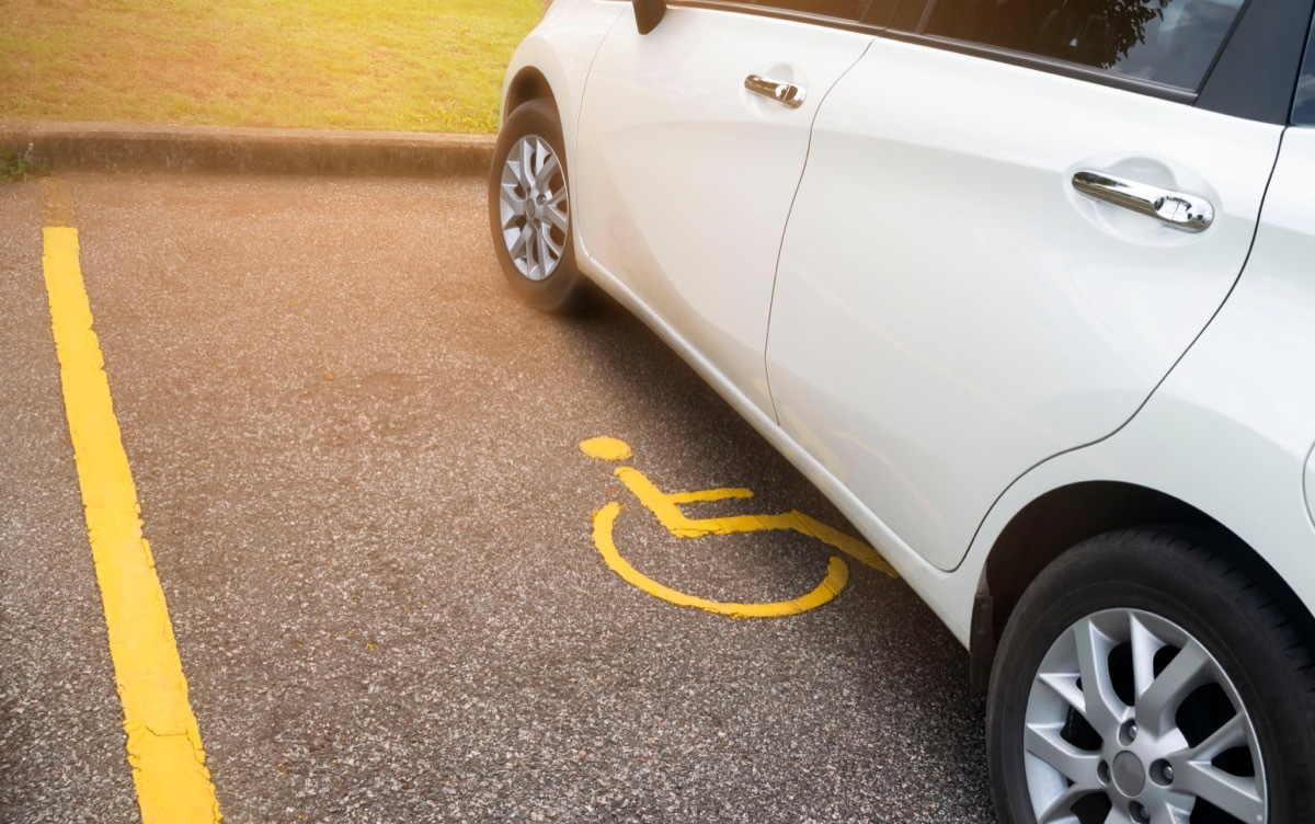 White car parking in handicapped parking spot