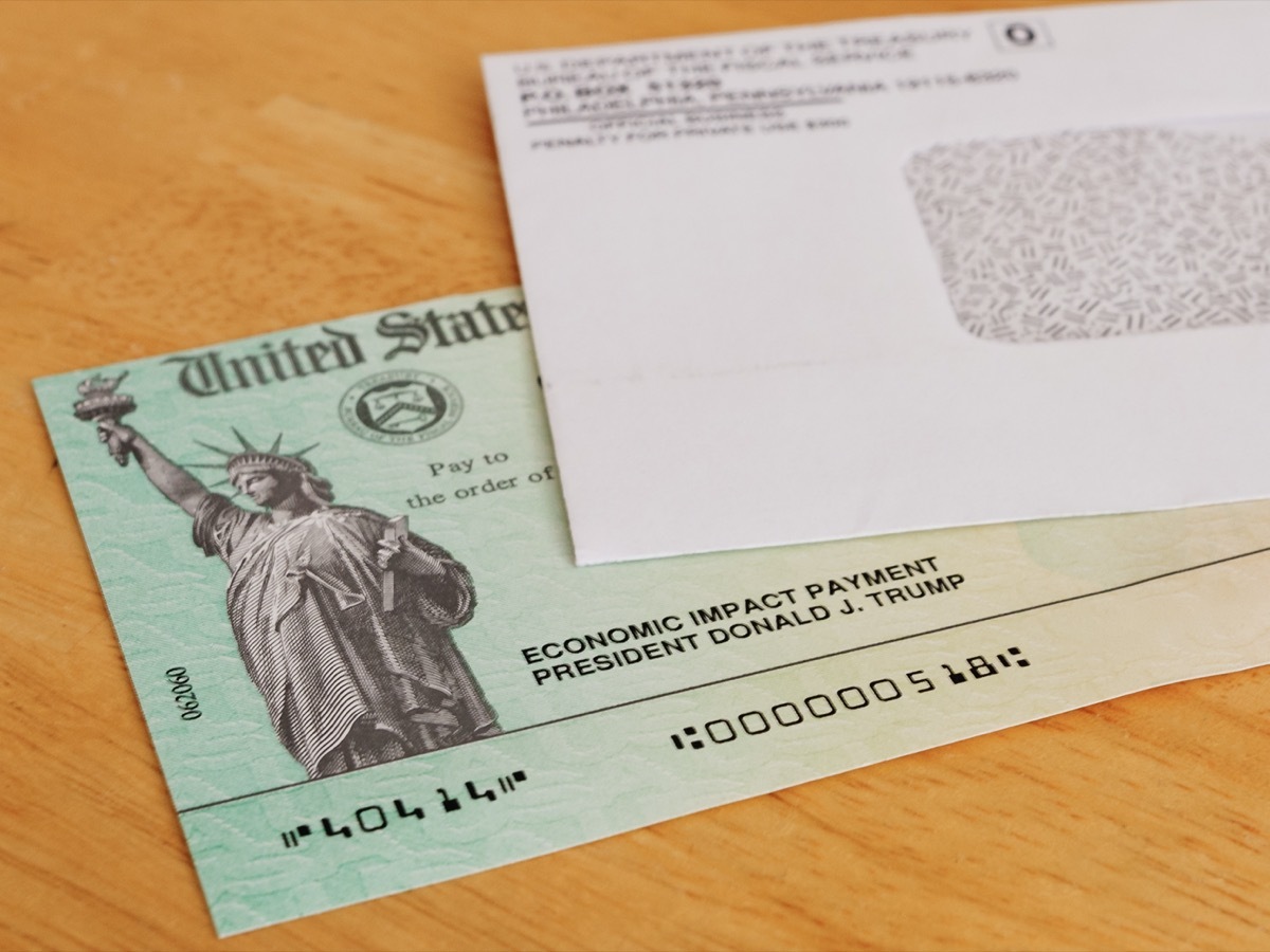 stimulus check and envelope on a wooden table