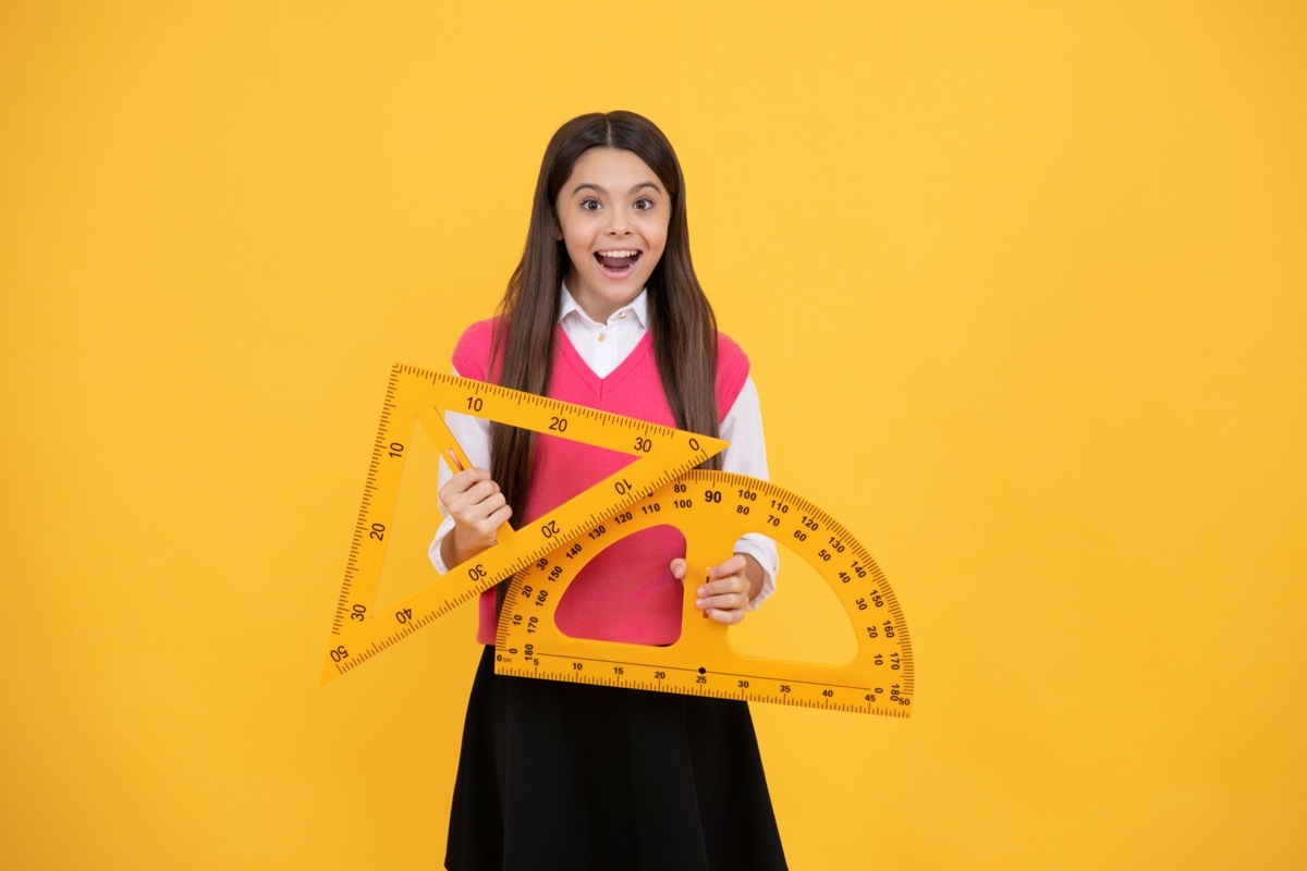 Girl holding up geometry tools