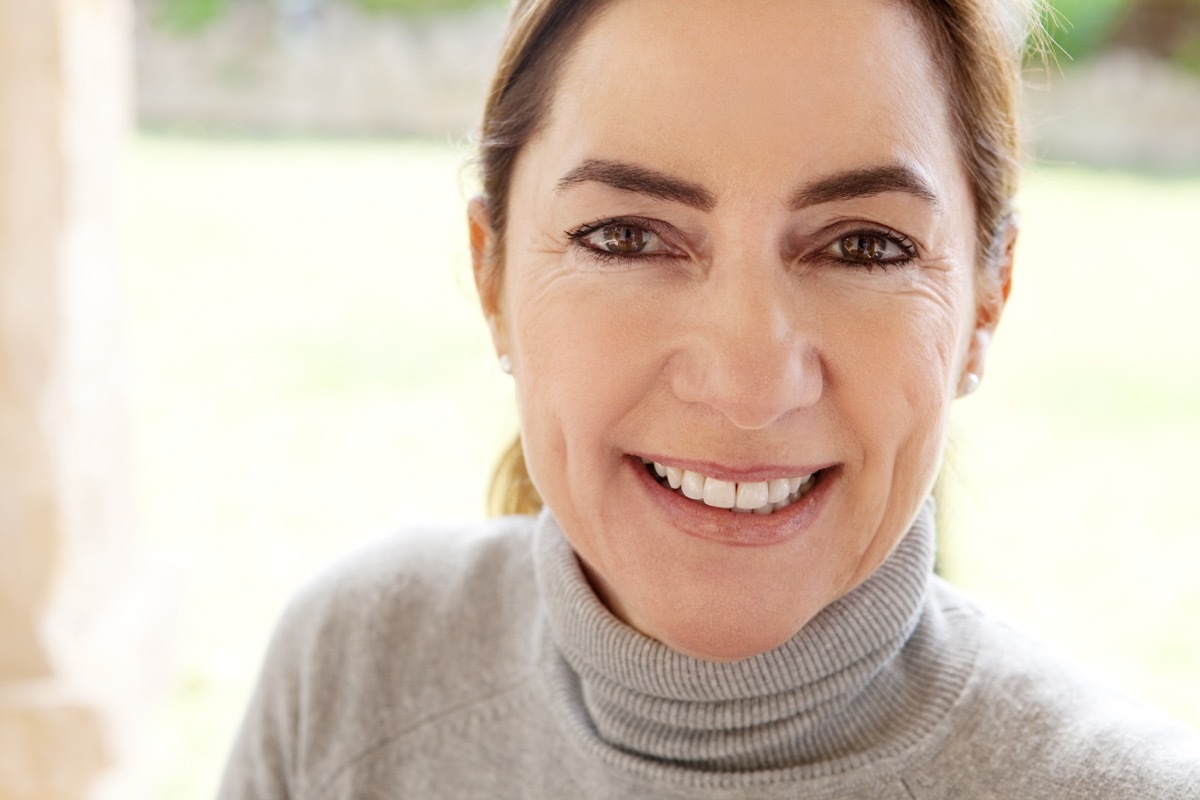 middle aged woman smiling and wearing a turtleneck